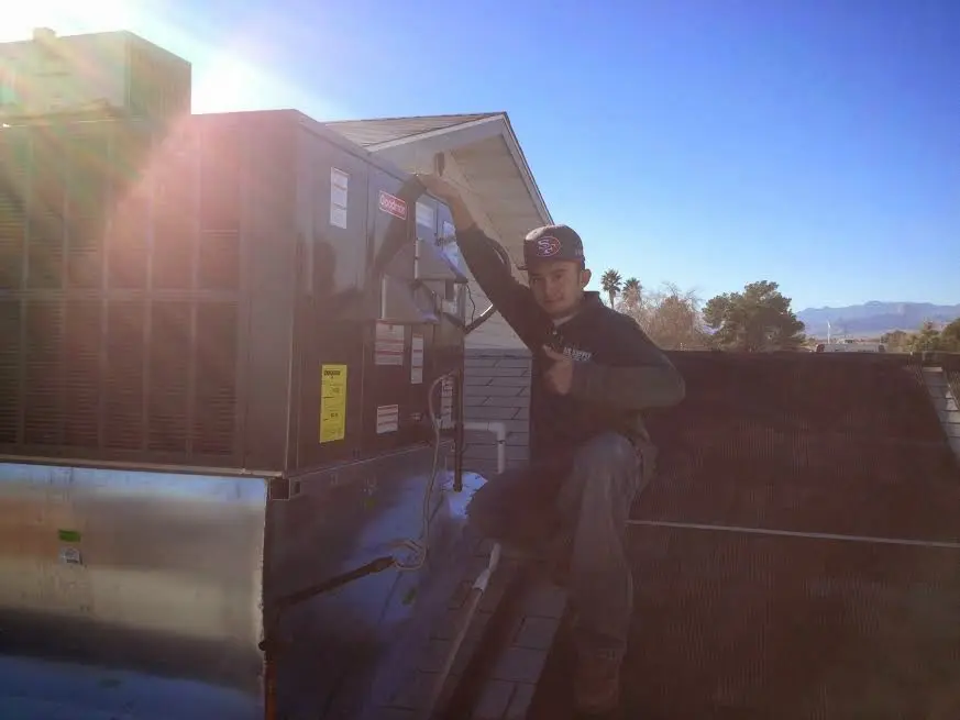 HVAC technician performing AC Tune-Up on a rooftop unit in Newark